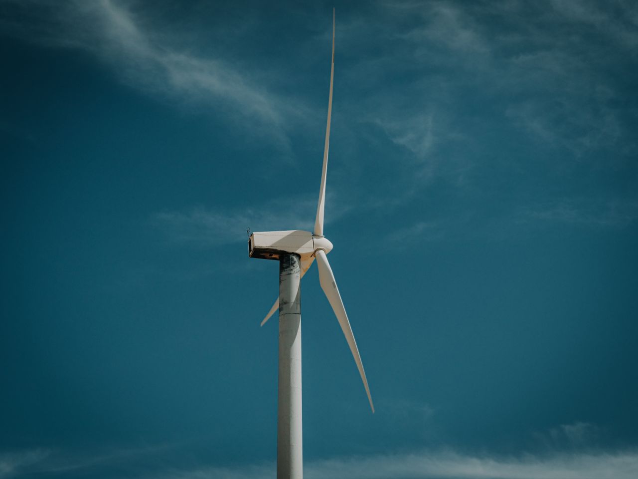 Home Wind turbine against a clear blue sky, symbolizing renewable energy.